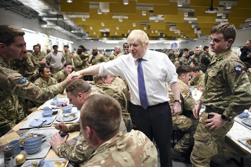 TALLINN, ESTONIA - DECEMBER 21:  Prime Minister Boris Johnson serves Christmas lunch to British troops stationed in Estonia during a one-day visit to the Baltic country on December 21, 2019 in Tallinn, Estonia. The base is home to 850 British troops from the Queen's Royal Hussars who lead the Nato battlegroup along with personnel from Estonia, France and Denmark. (Photo by Stefan Rousseau - Pool/Getty Images)