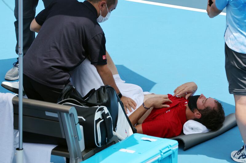 Russia's Daniil Medvedev is assisted by a physio during Tokyo 2020 Olympic Games men's singles third round tennis match against Italy's Fabio Fognini at the Ariake Tennis Park in Tokyo on July 28, 2021.  (Photo by Giuseppe CACACE  /  AFP)