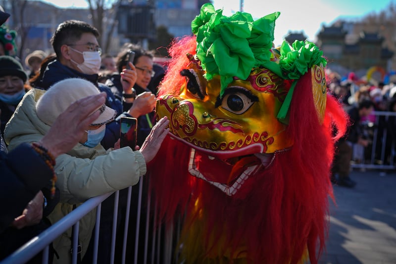 Residents touch the Lion Dance during a performance at the Dongyue Temple on the first day of the Chinese Lunar New Year in Beijing. AP Photo