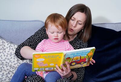 Opal Sandy reads with her mother Jo. PA