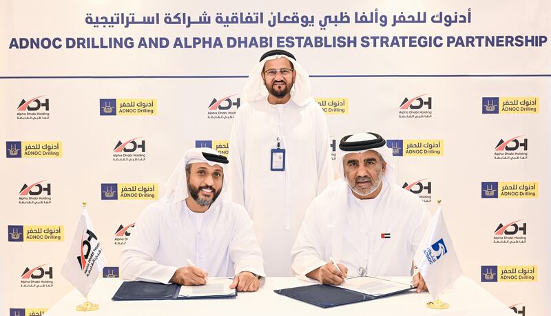 Hamad Al Ameri, left, group chief executive of Alpha Dhabi, and Abdulrahman Al Seiari, chief executive of Adnoc Drilling, right sign the pact, in the presence of Abdulmunim Al Kindy, Adnoc executive director, upstream directorate. Photo: Adnoc Drilling
