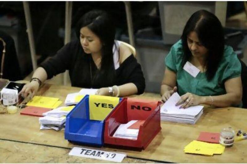 Workers count ballots for the referendum on the Alternative Vote, in a sports centre in Vauxhall, London, May 6,    2011. British voters punish the Liberal Democrats for their role in a deficit-cutting government on Friday, deserting the party in local elections and almost certainly rejecting its efforts to reform the electoral system.