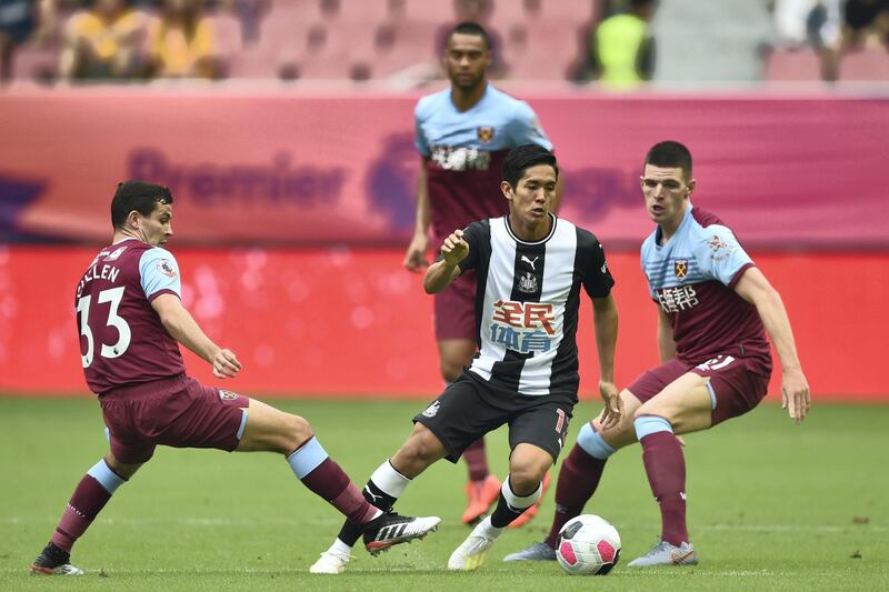 Newcastle United's forward Yoshinori Muto (C) is challenged by West Ham United's Josh Cullen (L) during their match for third place in the 2019 Premier League Asia Trophy football tournament at the Hongkou Stadium in Shanghai on July 20, 2019. (Photo by HECTOR RETAMAL / AFP)