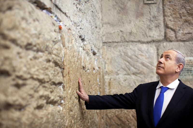 FILE PHOTO: Israel's Prime Minister Benjamin Netanyahu touches the Western Wall in Jerusalem's Old City after casting his ballot for the parliamentary election January 22, 2013.  REUTERS/Uriel Sinai/Pool /File Photo