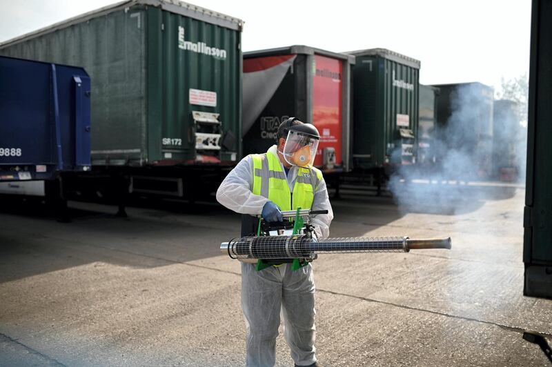 Business owner Chris Johnson uses a thermal fogger to disinfect trucks at a haulage firm in Barnsley,  south Yorkshire on April 22, 2020, during the nationwide lockdown due to the novel coronavirus COVID-19 pandemic. - Oxford University is launching a human trial of a potential coronavirus vaccine, with the daunting aim of making a succesful jab available to the public later this year. (Photo by Oli SCARFF / AFP)