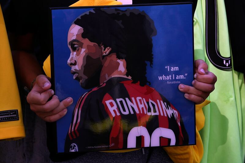 A fan holds a poster of former soccer star Ronaldinho as the city tries to rebuild the port amid Lebanon's worsening economic crisis.