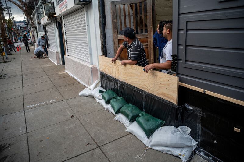 Workers build a flood protection barrier at the entrance of a business in the Mission District of San Francisco. Bloomberg