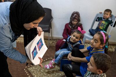 In this May 2017 photo Photo courtesy of Parisa Azad and the Sesame Workshop, children take part in formative research conducted by Sesame Workshop and International Rescue Committee at a women's center in Mafraq, Jordan. The John D. and Catherine T. MacArthur Foundation announced Wednesday, Dec. 20, 2017, that Sesame Workshop and International Rescue Committee will get a $100 million grant from a Chicago-based foundation. for a joint program that will include home visits focused on early learning, child development centers and a local version of "Sesame Street." (Parisa Azad/Sesame Workshop via AP)