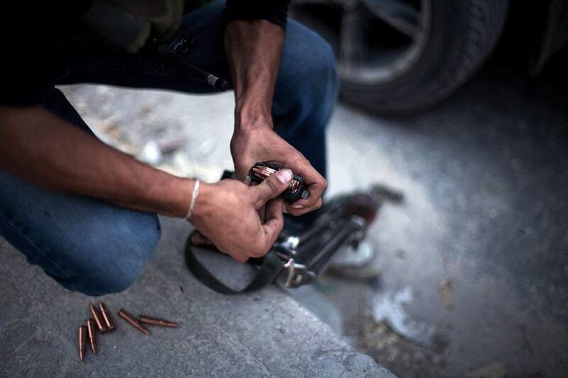 A rebel soldier reloads his machine gun cartridge during a break in the fighting. Manu Brabo / AP Photo