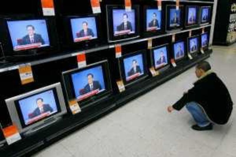 A customer in a supermarket in Wuhan, Hubei province, watches the television broadcast of China's Premier Wen Jiabao speaking at a news conference March 13, 2009.    REUTERS/Stringer (CHINA BUSINESS POLITICS) CHINA OUT. NO COMMERCIAL OR EDITORIAL SALES IN CHINA *** Local Caption ***  PEK05_CHINA-WEN-_0313_11.JPG