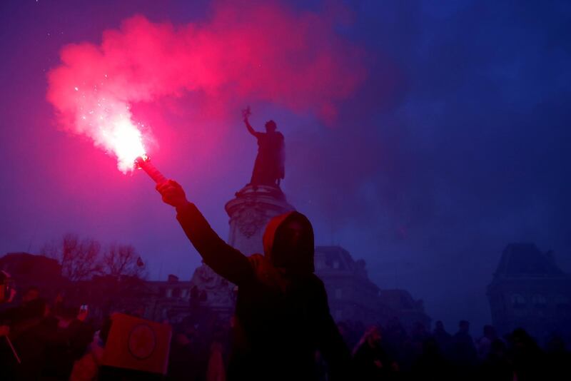 A protester holds a flare during a demonstration of French labour union members and workers, as France faces its 38th consecutive day of strike.  Reuters