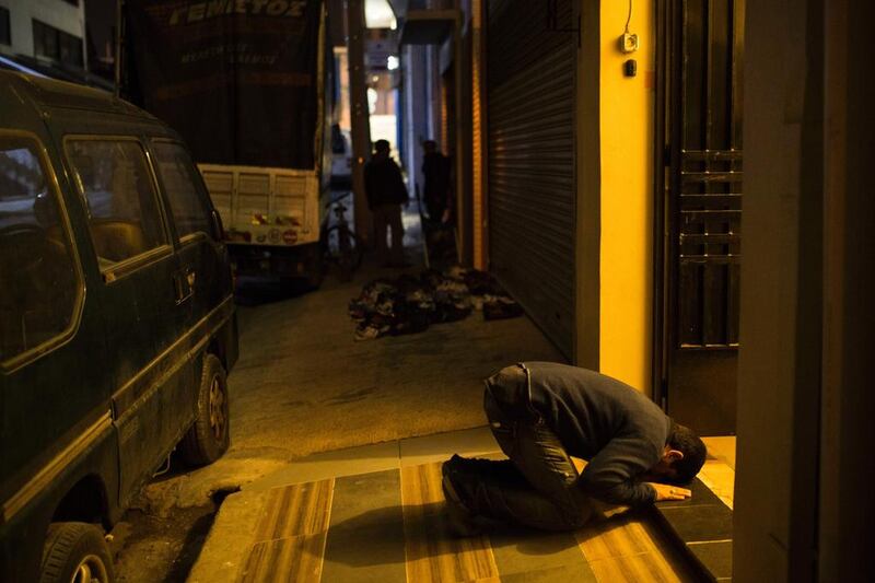 A muslim resident prays outside a mosque in Athens on February 18, 2017. Angelos Tzortzinis / AFP