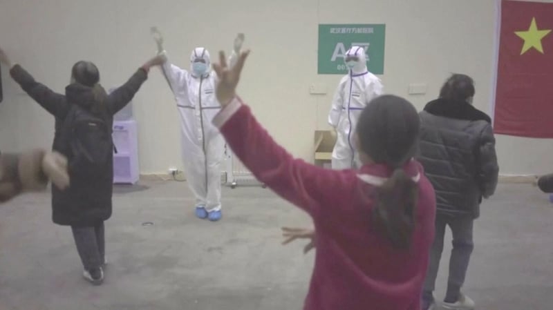 Coronavirus patients and medical staff dance to a lively Chinese song about red flowers at a makeshift hospital in Wuhan. China News Service via Reuters