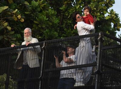 Bollywood actor Shah Rukh Khan (R) holds his son as he prepares to greet his fans during Eid al-fitr celebrations, next to US television host David Letterman (L) in Mumbai on June 5, 2019. / AFP / SUJIT JAISWAL
