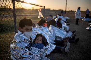 Asylum seekers take refuge near a baseball field after crossing into the US from Mexico. Reuters