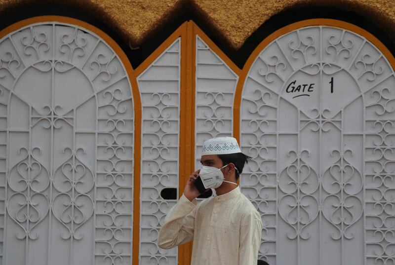 An Indian Muslim speaks on a mobile phone after the mosque door was closed due to insufficient space on Eid al-Adha in Hyderabad, India, Saturday, Aug.1, 2020. Eid al-Adha, or the Feast of the Sacrifice, is marked by sacrificing animals to commemorate the prophet Ibrahim's faith in being willing to sacrifice his son. (AP Photo/Mahesh Kumar A.)
