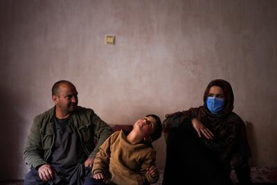 Sanam, a bacha posh, a girl living as a boy, sits next to her mother and father. AP