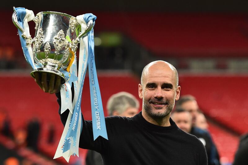 (FILES) In this file photo taken on March 01, 2020 Manchester City's Spanish manager Pep Guardiola celebrates with the trophy on the pitch after the English League Cup final football match between Aston Villa and Manchester City at Wembley stadium in London on March 1, 2020. Manchester City coach Pep Guardiola has donated one million euros ($1.08 million) to help buy medical supplies for the fight against the coronavirus pandemic in his native Spain. The former FC Barcelona boss gave the money to the Medical College of Barcelona to buy "medical equipment that is currently lacking in health centres in Catalonia," the body said in a statement.
 / AFP / Glyn KIRK                  

