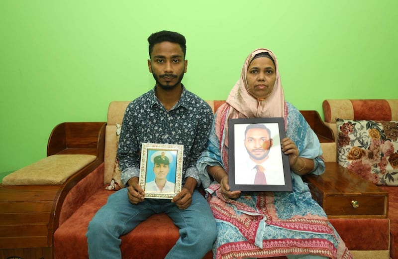 Ainul Hoque's brother Mainul and mother, Lutfa Ara, hold photos of him and await his return to Bangladesh. Photo: The Hoque family