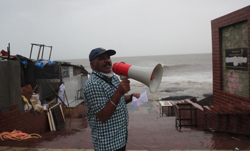 A municipal employee makes an announcement by the shore of the Arabian Sea in Mumbai, India. AP Photo