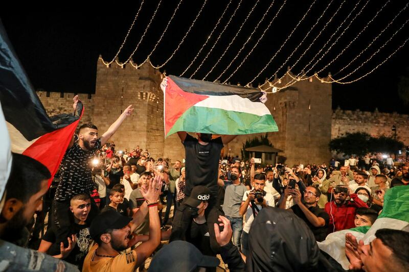 Palestinians wave flags and celebrate outside Damascus Gate after barriers that were put up by Israeli police are removed, allowing them to access the main square that has been the focus of a week of clashes around Jerusalem's Old City. Reuters