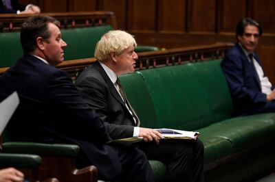In this handout photo provided by UK Parliament, Britain's Prime Minister Boris Johnson looks on during Prime Minister's Questions in the House of Commons in London, Wednesday, Sept. 23, 2020. The British government is defending its strategy for combating a second wave of COVID-19 cases amid criticism that its new slate of restrictions will not be enough to stop an exponential spread of the coronavirus. Prime Minister Boris Johnson has unveiled new rules that include a 10 p.m. curfew on bars and restaurants and again encouraged people to work from home. (Jessica Taylor/UK Parliament via AP)