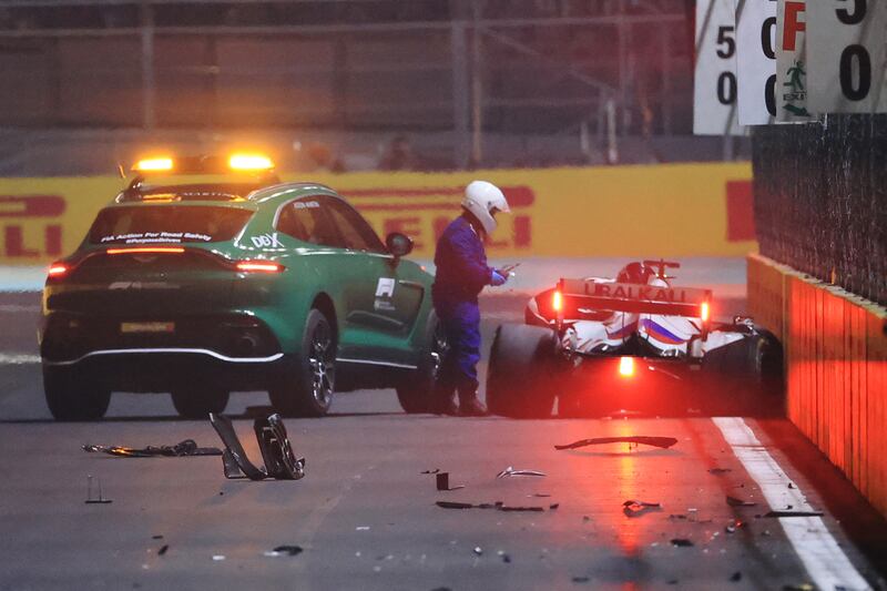 A race marshal assists Haas driver Mick Schumacher after his crash. AFP