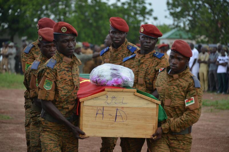 Soldiers carry the coffin of one of the victims during the funeral ceremony of the seven members of the security forces killed three days ago after their vehicle struck a roadside bomb in eastern Burkina Faso, on August 31, 2018 in Ouagadougou. - The fatalities were gendarmes and troops who had been sent to the town of Pama as reinforcements after a police station there came under attack, they said. (Photo by STR / AFP)