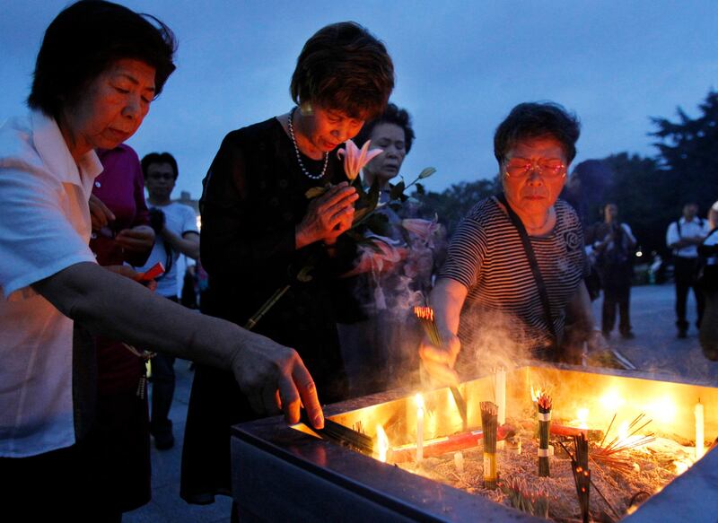 People pray before the cenotaph for the atomic bombing victims before the start of the 66th anniversary of the atomic bombing at Hiroshima Peace Memorial Park in Hiroshima, western Japan, Saturday, Aug, 6, 2011.  (AP Photo/Koji Sasahara) *** Local Caption ***  Japan Hiroshima atomic Bomb anniversary.JPEG-09b65.jpg