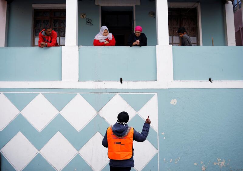 A health worker talks to residents as they conduct screening during the 21-day nationwide lockdown aimed at limiting the spread of coronavirus disease (COVID-19) in Bo Kaap, Cape Town, South Africa, April 7, 2020. REUTERS
