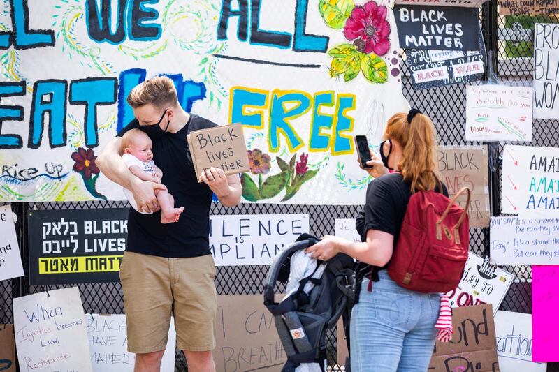 Signs hang along the security fence erected around the White House in response to protests over the death of George Floyd in police custody in Washington DC.  EPA