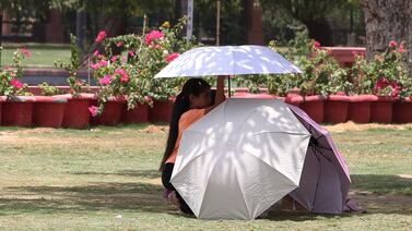 People shelter from the beating sun under umbrellas in New Delhi on Thursday. EPA