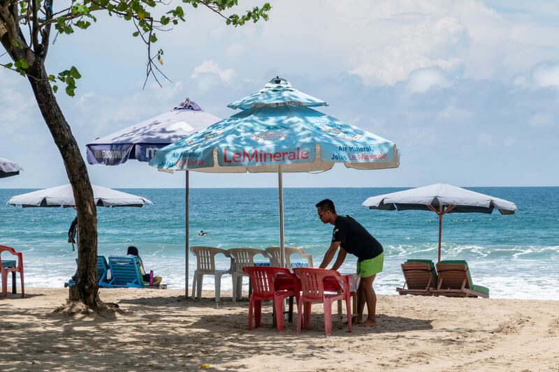 A man disinfects seats for tourists at a beach in Kuta, Bali, Indonesia. EPA