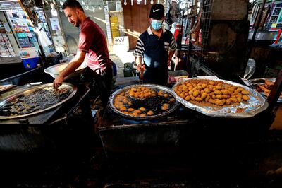Street venders make traditional sweets at old Basra market, Iraq, Wednesday, Oct. 21, 2020.  Iraq is in the throes of an unprecedented liquidity crisis, as the cash-strapped state wrestles to pay public sector salaries and import essential goods while oil prices remain dangerously low.(AP Photo/Nabil al-Jurani)