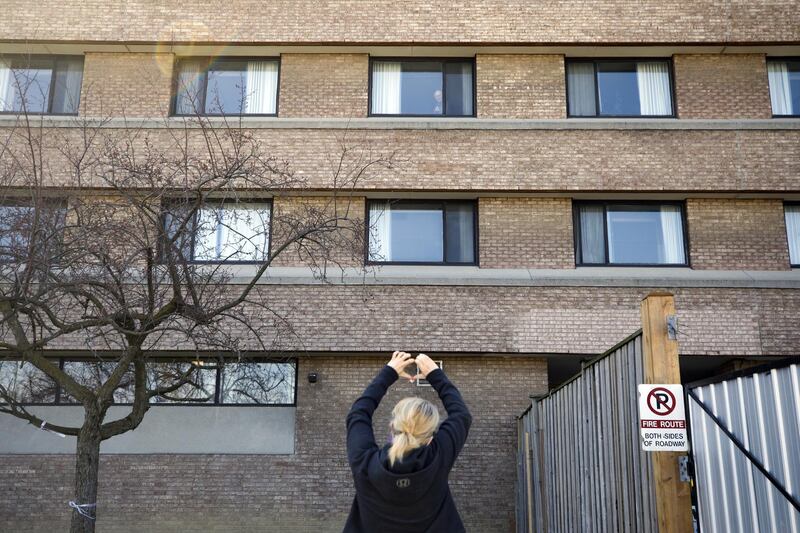 A relative gestures to a resident in a window at the Eatonville Care Centre, a long-term care home, in Toronto, Ontario, Canada, on Saturday, April 25, 2020. Canada's two largest provinces have called for military assistance to fight Covid-19 outbreaks they have been unable to get under control in long-term care facilities. Photographer: Cole Burston/Bloomberg