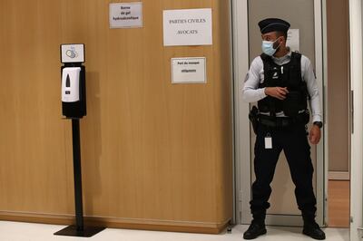 A police officier guards the courtroom at the Paris Hall of Justice Wednesday, Dec. 16, 2020 in Paris. The terrorism trial of 14 people linked to the January 2015 Paris attacks on the satirical weekly Charlie Hebdo and a kosher supermarket ends Wednesday after three months punctuated by new attacks, a wave of coronavirus infections among the defendants, and devastating testimony bearing witness to three days of bloodshed that shook France. (AP Photo/Michel Euler)