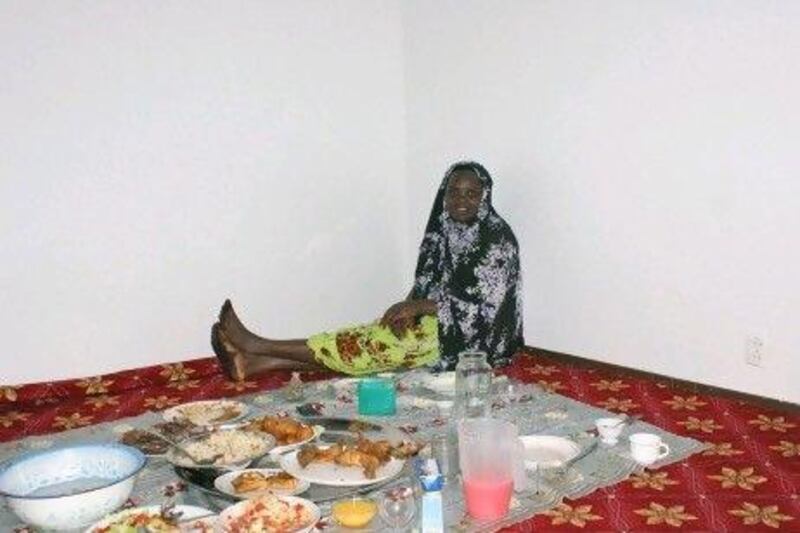 Kaltouma Abakar, a refugee from Sudan's Darfur province, sits on the floor of her living room during iftar in Rovaniemi Finland.