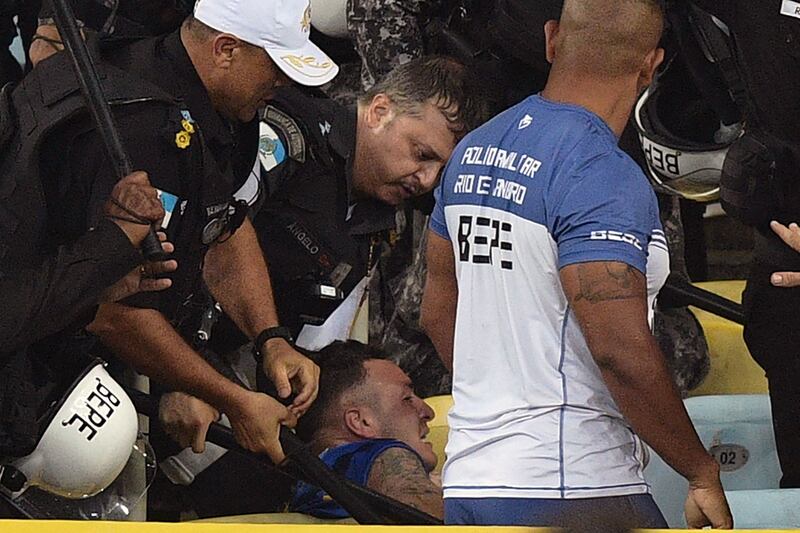 Brazilian police attempt to restrain an Argentina fan as fights break out in the stands. AFP