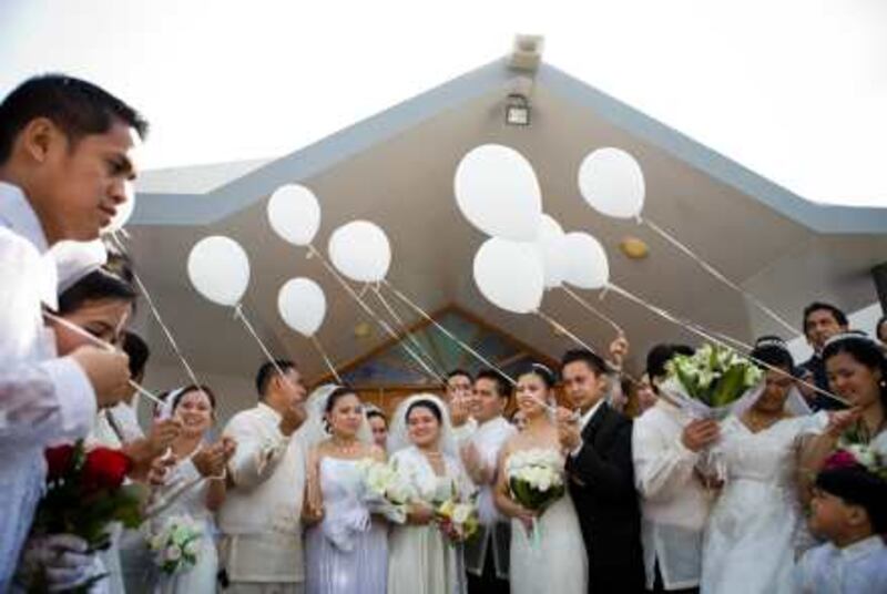 Dubai - December 2, 2009: Balloons were released into the open air following a mass wedding were fourteen couples in the Filipino community were married in St. Mary's Church. Lauren Lancaster / The National
 *** Local Caption ***  LL0212-groupwedding023.jpg