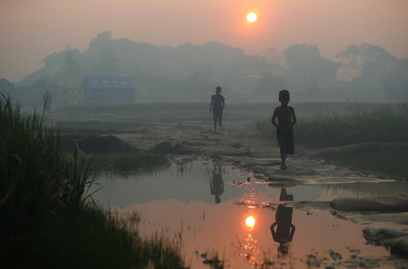 Rohingya refugees walk through Palong Khali refugee camp at sunrise, near Cox's Bazar, Bangladesh. Hannah McKay / Reuters