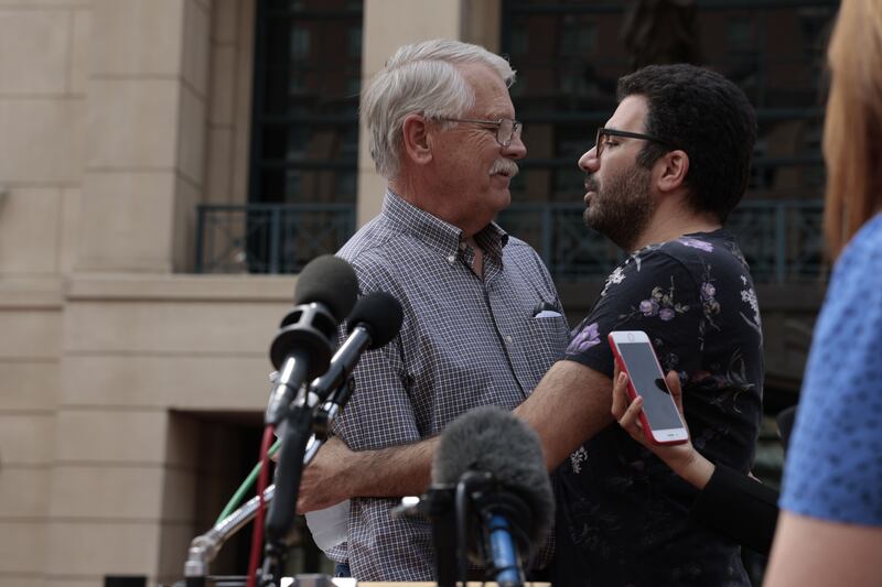 Carl Mueller - the father of Kayla Mueller who was killed by ISIS militants - hugs one of Kayla's friends, Rodwan Safar Jalani, after the announcement of the guilty verdict for ISIS member El Shafee Elsheikh. AFP
