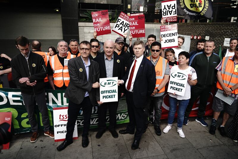 General secretary of the Rail, Maritime and Transport union  Mick Lynch, centre, with striking workers at London Euston train station. PA