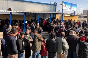 People queue to buy bread in the city of Aleppo in Syria, where a shortage of basic goods has created demand for products smuggled from Lebanon. Anadolu Agency via Getty Images