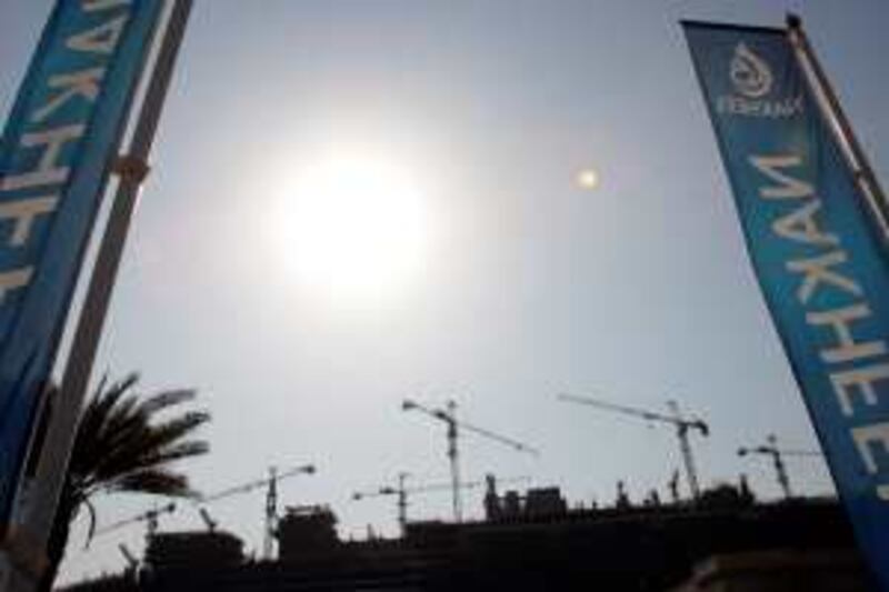 Banners of Dubai property giant Nakheel stand in front of a building site in Dubai on November 30, 2008. Nakheel, the Dubai government-controlled developerbehind such grandiose projects as a one-kilometre tower and artifical palm-shaped islands, said today it has fired 500 staff as the global economic crisis begins to bite in the oil-rich Gulf. AFP PHOTO/KARIM SAHIB