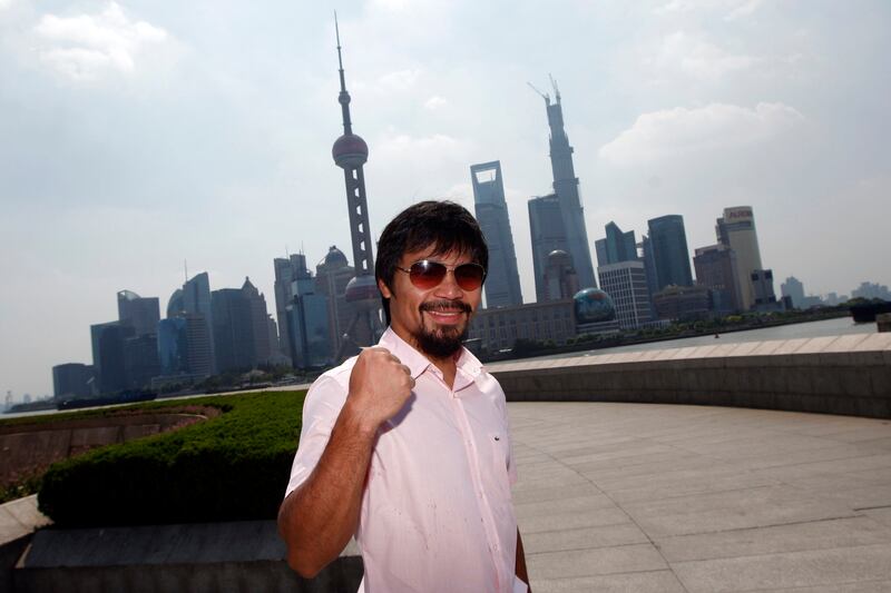 Filipino boxer Manny Pacquiao poses before a news conference at The Bund, in front of the financial district of Shanghai July 31, 2013. Pacquiao will challenge Brandon Rios of the U.S. in a welterweight boxing match in Macau on November 24. REUTERS/Aly Song (CHINA - Tags: SPORT BOXING) *** Local Caption ***  SHA103_BOXING-_0731_11.JPG