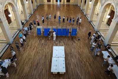 Voters queue at a polling station to vote in the first round of the French parliamentary election in Lyon. AP