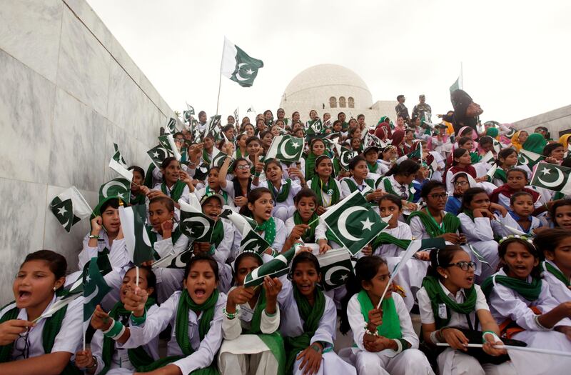 Attendees wave Pakistan's national flag while singing national songs at a ceremony to celebrate the country's 70th Independence Day at the mausoleum of Muhammad Ali Jinnah in Karachi, Pakistan August 14, 2017. REUTERS/Akhtar Soomro