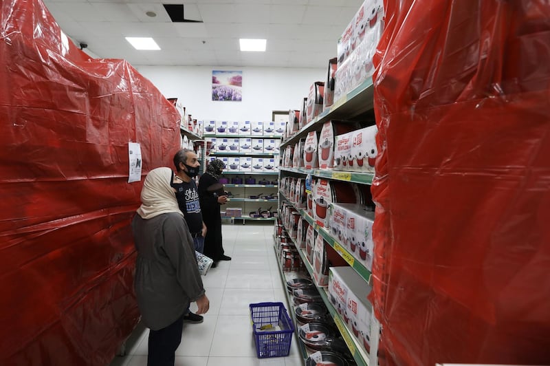 People shop at a mall next to covered French products in protest against French cartoons of the Prophet Mohammed in Amman, Jordan. Reuters