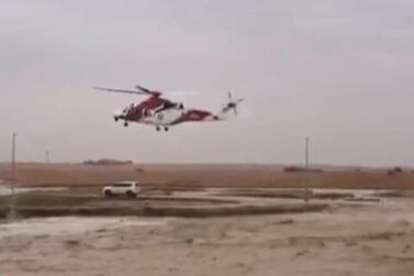 A helicopter swoops to the rescue of an Emirati couple stranded in flood-hit Al Ain as storms continue to cause massive disruption across the country. Courtesy: National Search and Rescue Centre  