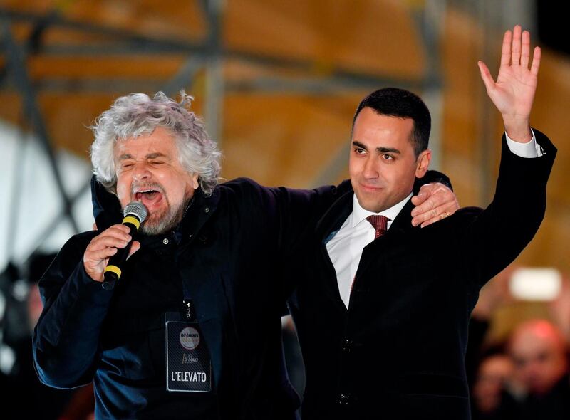 Italy's populist Five Star Movement (M5S) founder Beppe Grillo and M5s leader Luigi Di Maio (R) hug at the end of the last election campaign meeting in Piazza del Popolo square in Rome on March 2, 2018.
Italy's anti-establishment Five Star Movement broke with tradition on March 1, 2018, by announcing its list of ministerial candidates, almost all of them political newcomers, before March 4 general election. / AFP PHOTO / Andreas SOLARO